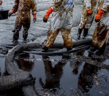 volunteers cleaning up a beach from a oil slick on Ao Phrao beach on Samed Island, rayong, Thailand.